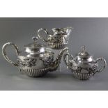 A CHINESE SILVER THREE-PIECE TEA SERVICE of round semi-fluted shape, each with band of encircling