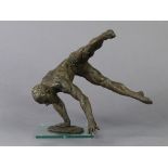 A contemporary resin sculpture depicting a male gymnast in handstand; mounted on glass square