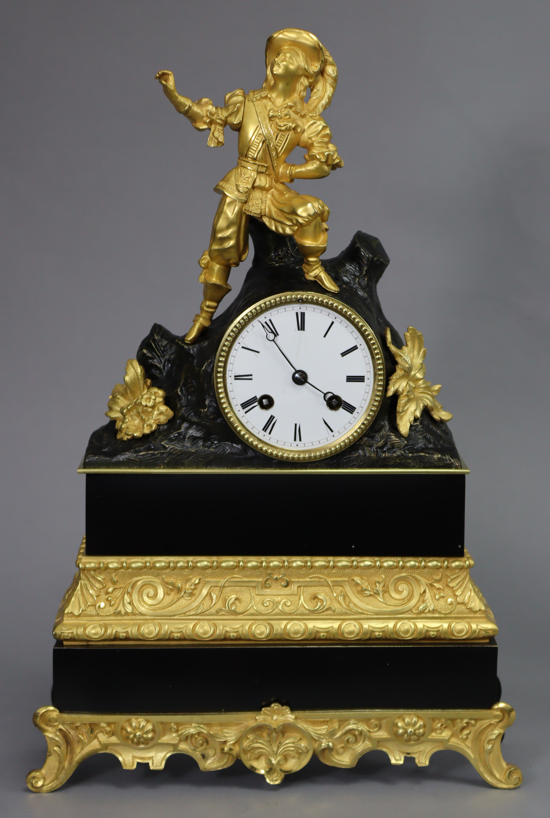 A 19th century French mantel clock in ebonised & gilt speltre case with figural surmount depicting a