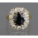 A sapphire & diamond ring, the oval sapphire set within a border of ten small diamonds, to a