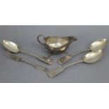 A silver oval sauce boat with gadrooned rim, C-scroll handle, & on three pad feet, 5½” long,