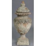 An antique terracotta garden urn, the removable cover with acorn finial, the body with foliate reli