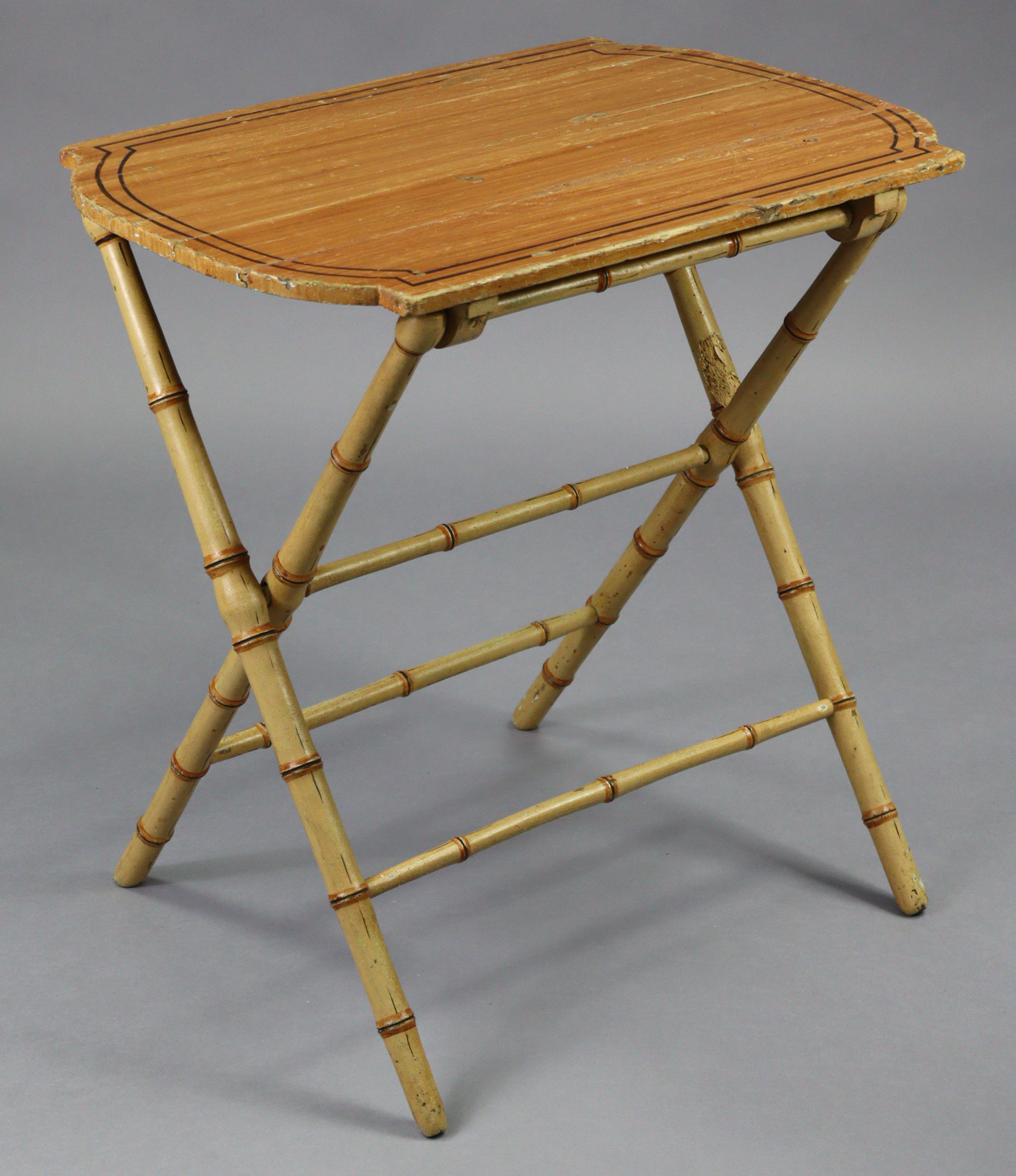 A Victorian painted coaching table with shaped rectangular top on faux-bamboo folding legs; 28” wide