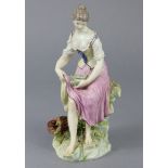 An 18th century Ludwigsburg porcelain figure of a woman seated bare-foot on a rock, holding a