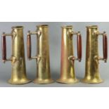 A set of four Arts & Crafts brass ewers of narrow tapered cylindrical shape, each with turned wood