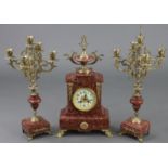 A 19th century French rouge marble & brass clock garniture, the 3½” white enamel dial with Arabic