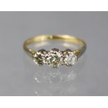 A three-stone diamond ring, the centre stone approx. 0.25 carat, the shank marked: “18ct. & Plat”;