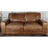 A tan leather three-seater settee with square back, & with loose cushions to the seat & back, 78”