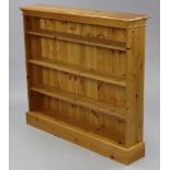 A pine standing open bookcase with three adjustable shelves, & on plinth base, 47½” wide x 42”