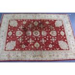 A large Turkish rug of crimson & cream ground, with repeating floral design to centre within a