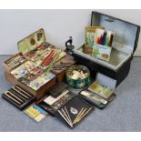 Three japanned-metal student’s paint boxes; together with various pens & pencils; a small japanned-