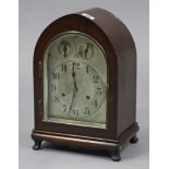An early 20th century mantel clock with silvered dial, chiming movement, & in mahogany case with