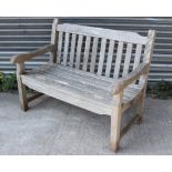 A teak slatted garden bench, on square legs with plain stretchers, 48” long.