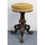 A Victorian mahogany piano stool with padded & revolving circular seat, & on fluted & carved