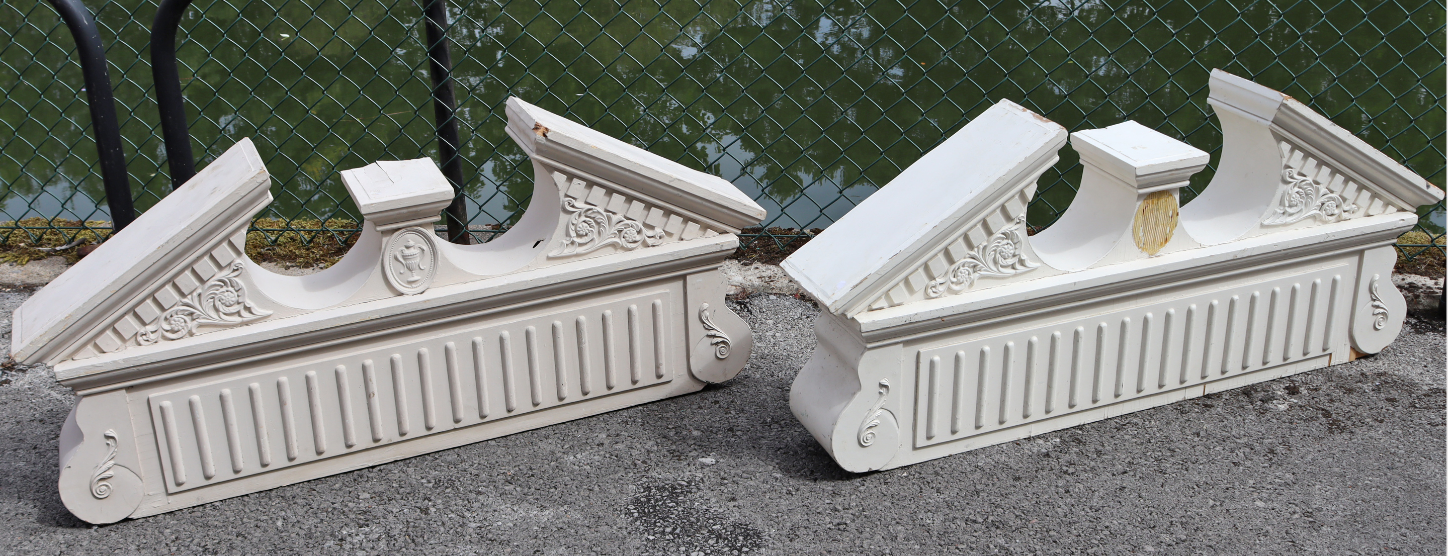 A pair of white-painted wooden architectural broken-arch pediments with moulded classical