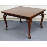 An early 20th century walnut extending dining table, with moulded edge & rounded corners to the