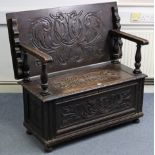 A late Victorian-style carved oak monk’s bench, with fold over top, hinged compartment to the box