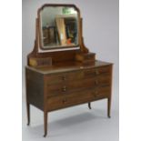 An Edwardian inlaid-mahogany dressing chest, with bevelled rectangular swing mirror to the stage
