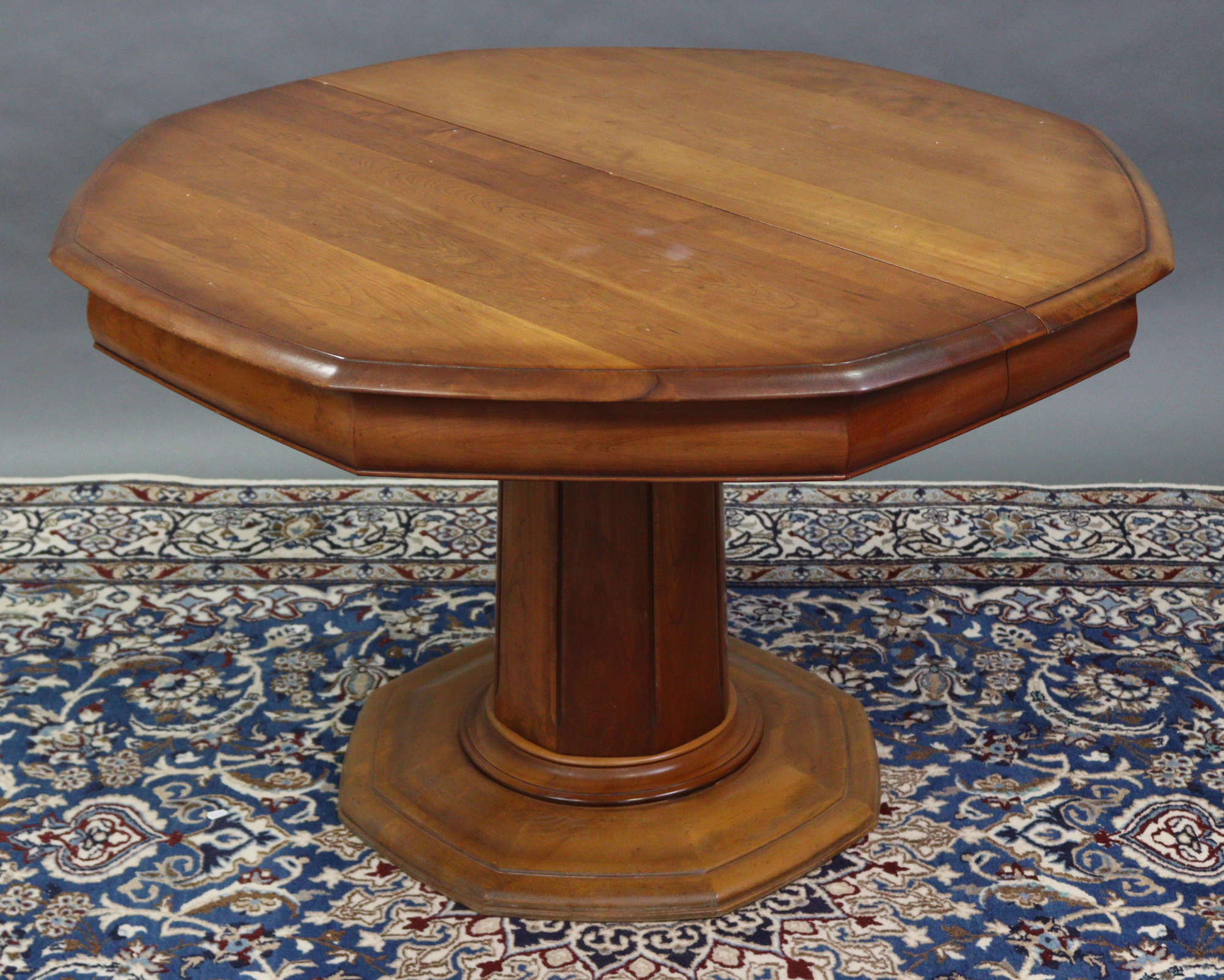 An “ESIGENCE” (Made in France) cherry wood octagonal extending dining table with two additional