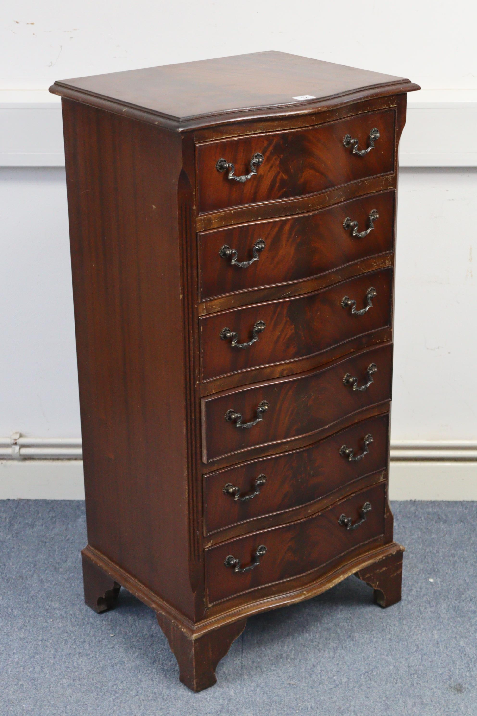 A reproduction mahogany small upright serpentine-front chest, fitted six long drawers with cast-