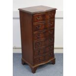 A reproduction mahogany small upright serpentine-front chest, fitted six long drawers with cast-