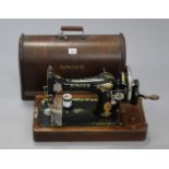 A Singer hand sewing machine with oak case.