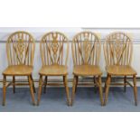 A set of four wheel-back dining chairs with hard seats, & on turned legs with spindle stretchers. (