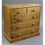 A pine chest, fitted two short & three long graduated drawers with turned knob handles, & on