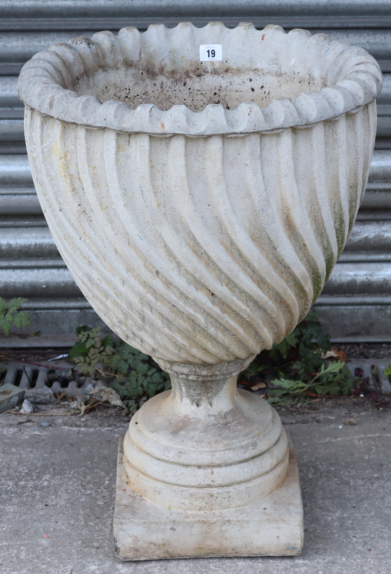 A reconstituted-stone garden urn of spiral-fluted design, & on square pedestal foot, 18” diam x