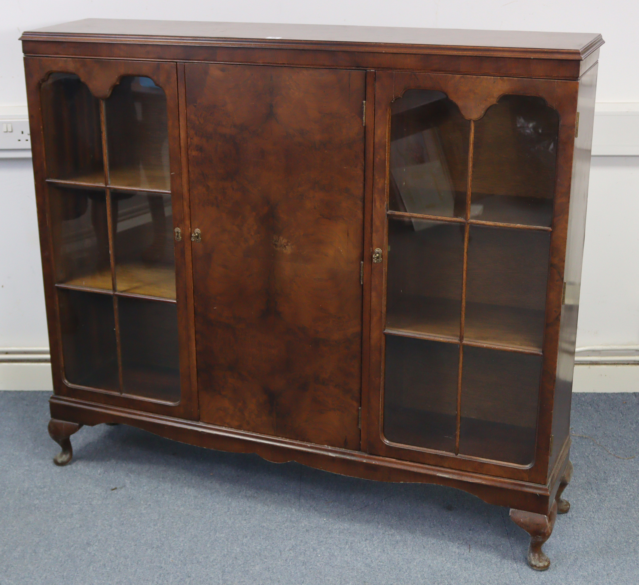 A mid-20th century walnut bookcase, with six adjustable shelves enclosed by panel door to centre