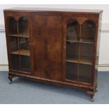 A mid-20th century walnut bookcase, with six adjustable shelves enclosed by panel door to centre