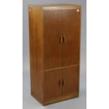 A mid-20th century oak upright cupboard, enclosed by two pairs of panel doors, & on plinth base, 22”