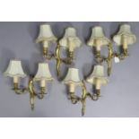 A set of four 19th century-style gilt metal twin-branch wall scones, 10” wide x 10¼” high, with