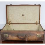 An early-mid 20th century leather-bound & fibre-covered suitcase with brass twin lever locks,