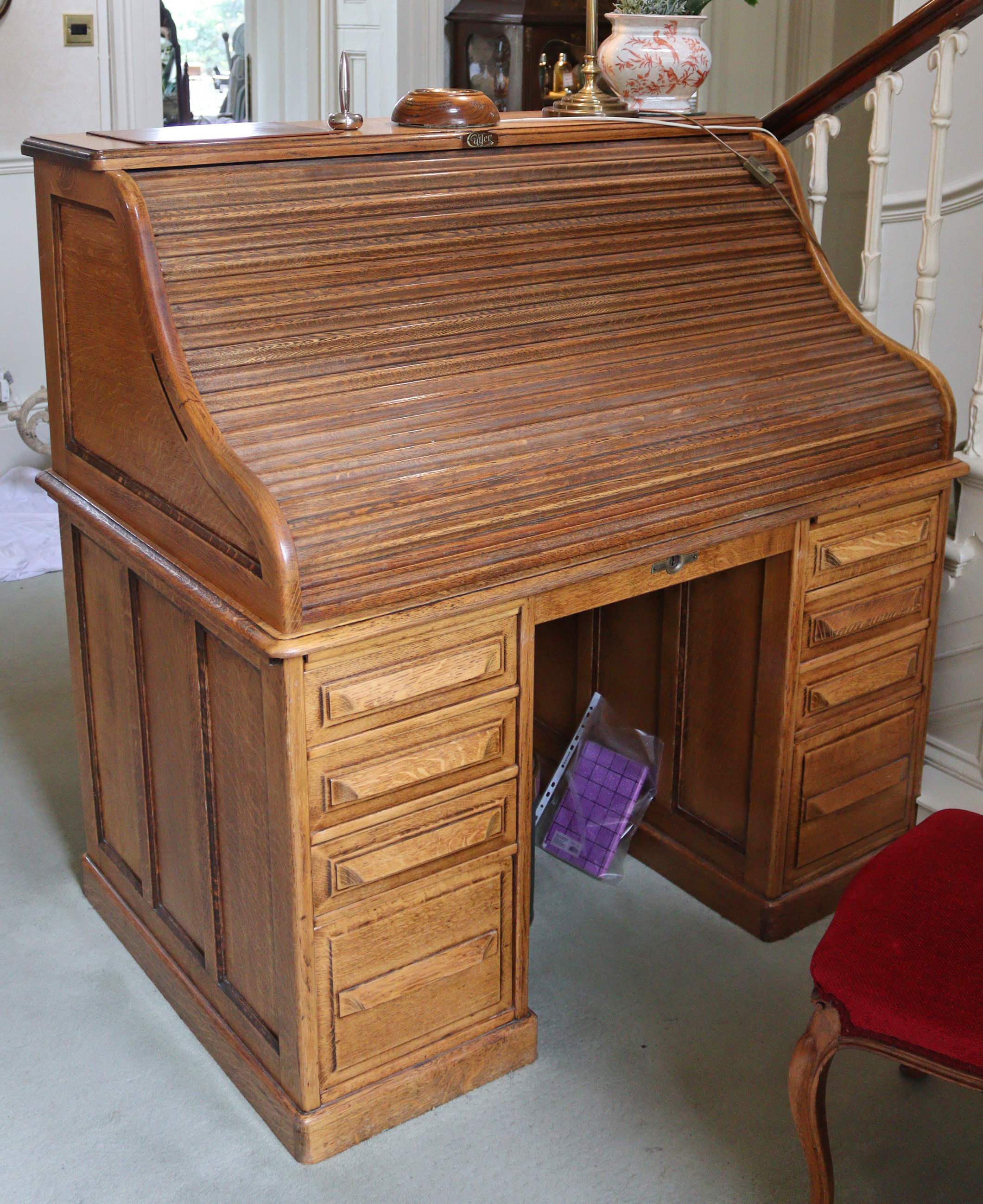 A late 19th/early 20th century Cutler oak roll-top desk with fitted interior enclosed by tambour