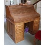 A late 19th/early 20th century Cutler oak roll-top desk with fitted interior enclosed by tambour
