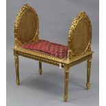 A continental-style carved giltwood window seat, inset woven-cane oval panel to either side, with