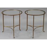 A pair of gilt-metal occasional tables, each inset plate-glass to the circular top, & on three
