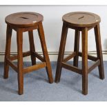 A pair of oak bar stools, each with circular seat, & on square chamfered legs with plain stretchers,