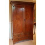 An Edwardian mahogany wardrobe with moulded cornice, enclosed by pair of panel doors above two