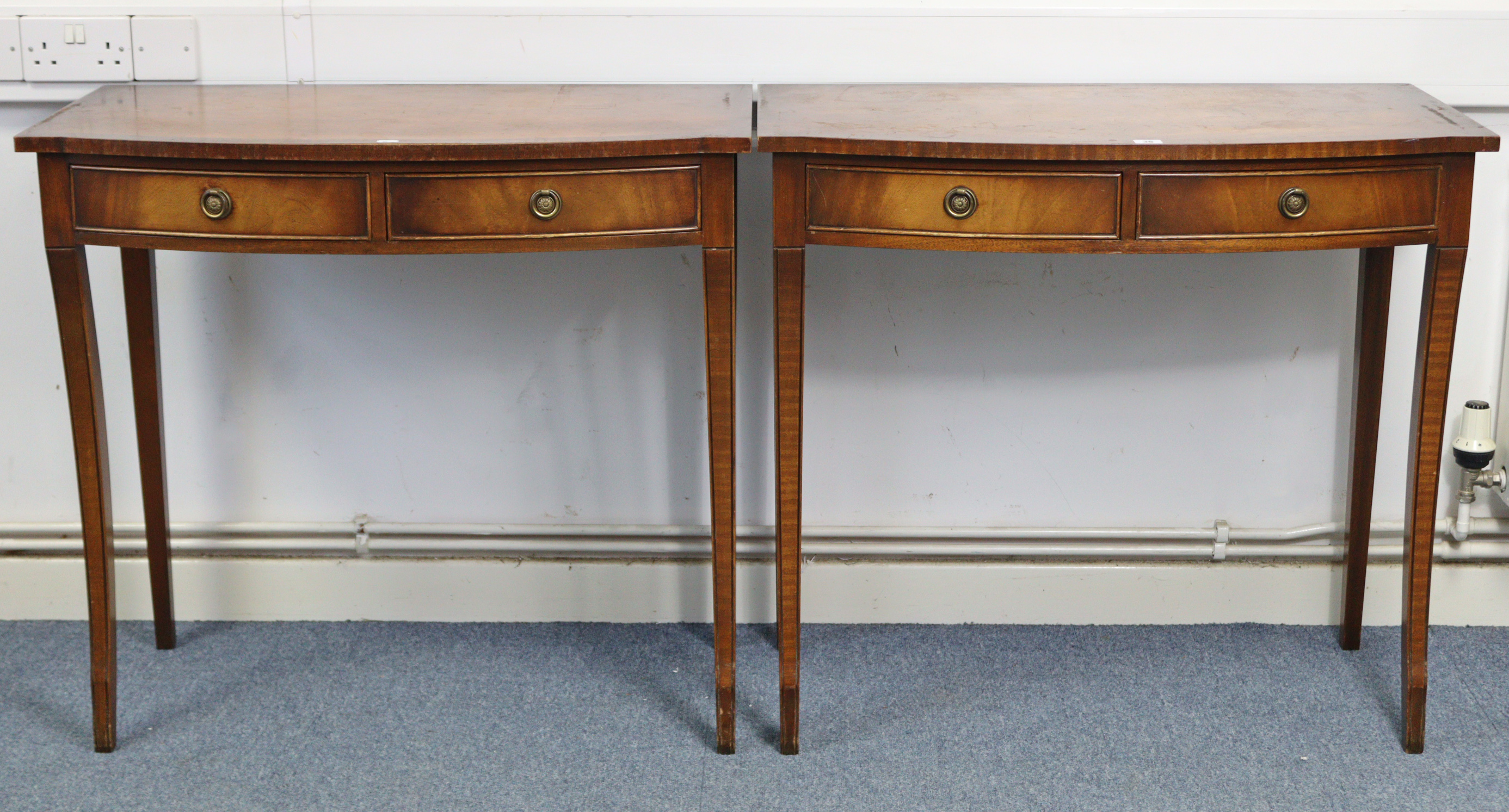 A pair of reproduction mahogany crossbanded bow-front side tables, each fitted two frieze drawers, &