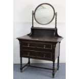 A mid-20th century oak dressing chest with circular swing mirror to the stage back, fitted two