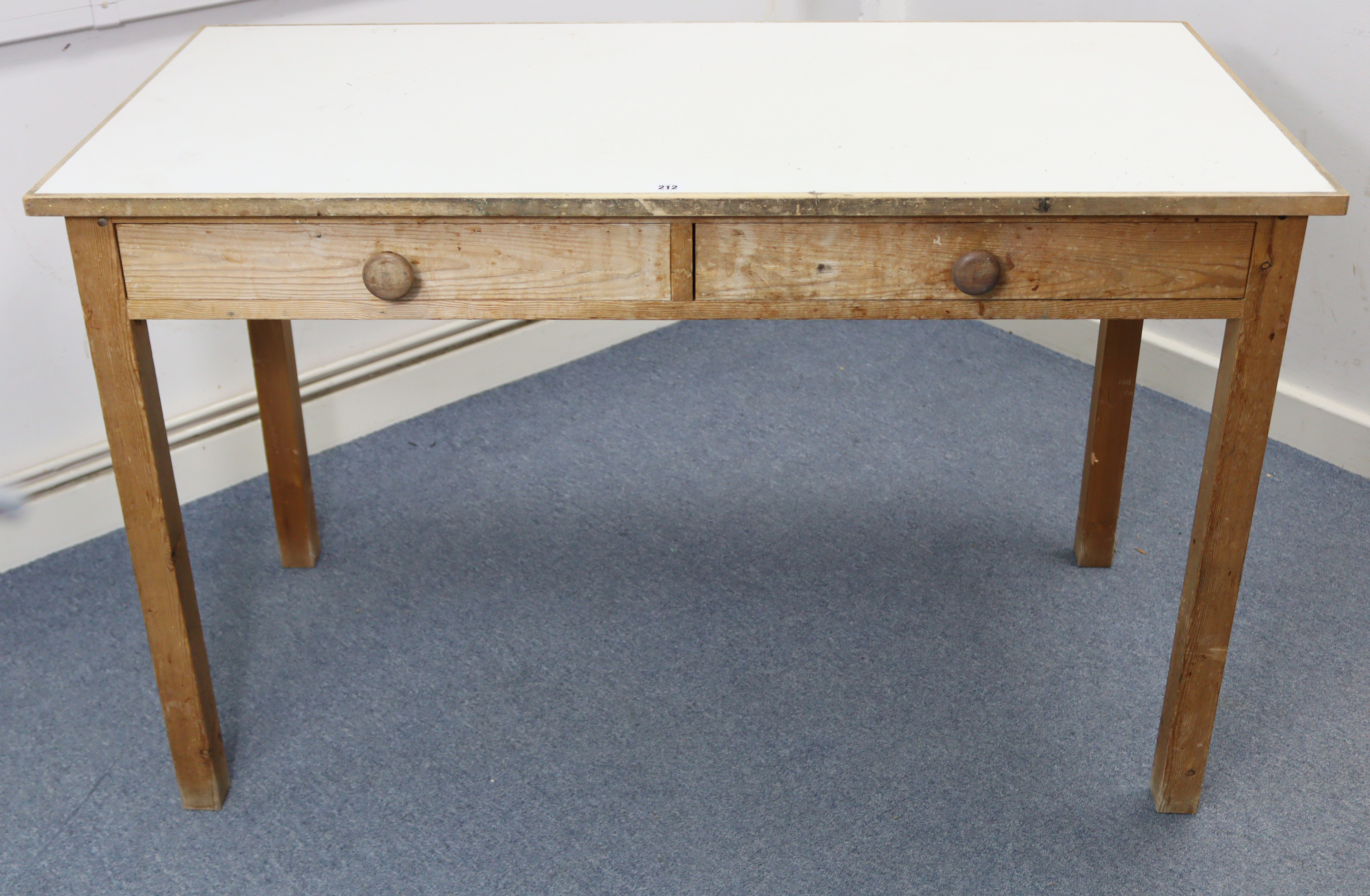 A pine kitchen table inset white Formica to the rectangular top, fitted two frieze drawers, & on