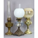 Three oil table lamps, two with shades.