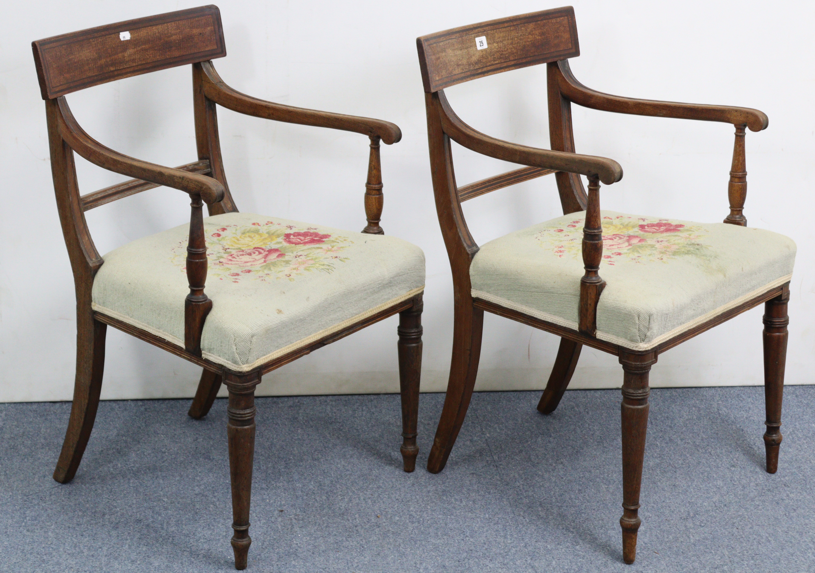 A pair of regency mahogany bow-back carver chairs with padded seats, on turned tapered legs.