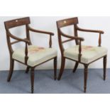 A pair of regency mahogany bow-back carver chairs with padded seats, on turned tapered legs.