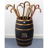 An ebonised oak & copper bound barrel stick stand with coat-of-arms to the front, 24¼” high; &