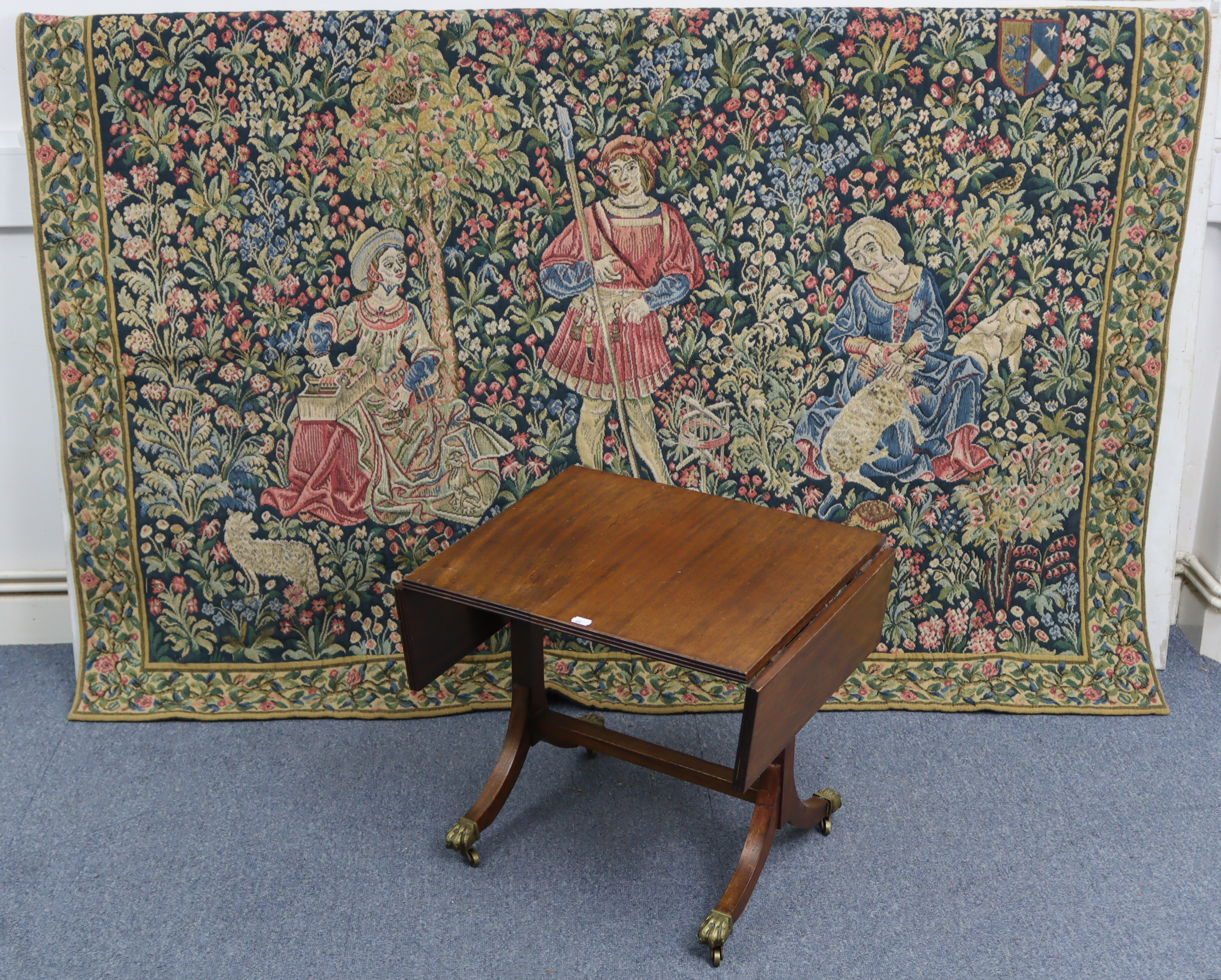 A reproduction tapestry depicting three figures in a garden scene, 70½” x 50”; together with a