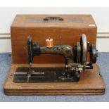 A Frister & Rossman hand sewing machine with case; & two modern wall clocks.