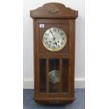 A 1920’s wall clock with silvered dial, striking movement & in oak case enclosed by bevelled